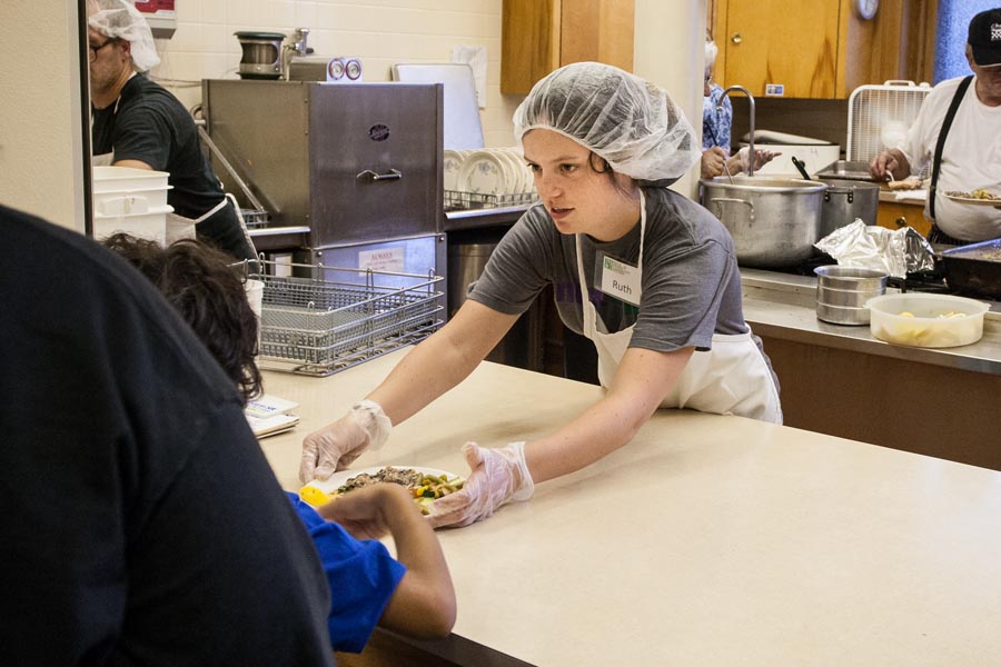 Knox College student serves a meal at the Knox Prairie Community Kitchen.