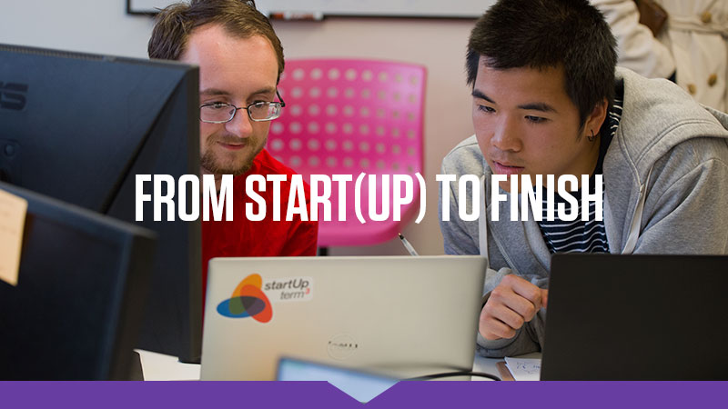 From Start(Up) to Finish: Two students peer intently at a laptop, emblazoned with a StartUp Term3 logo on the back.