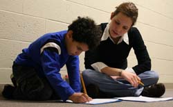 A Knox student volunteer works with an elementary school student.
