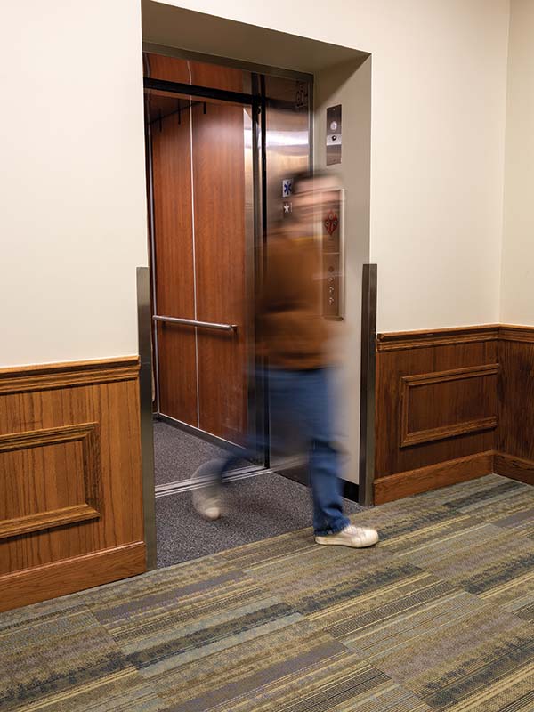 A student walking out of the elevator in GDH. 