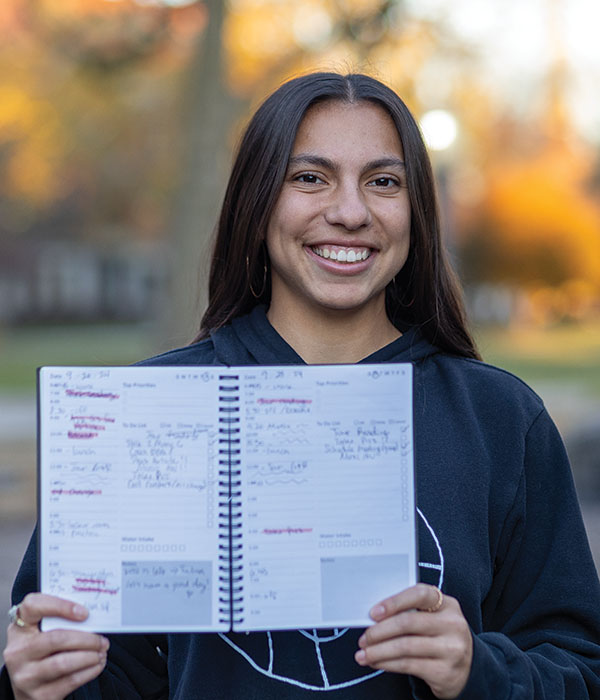 Student Aleene Ramirez holding her planner that helped her manage her time at Knox.