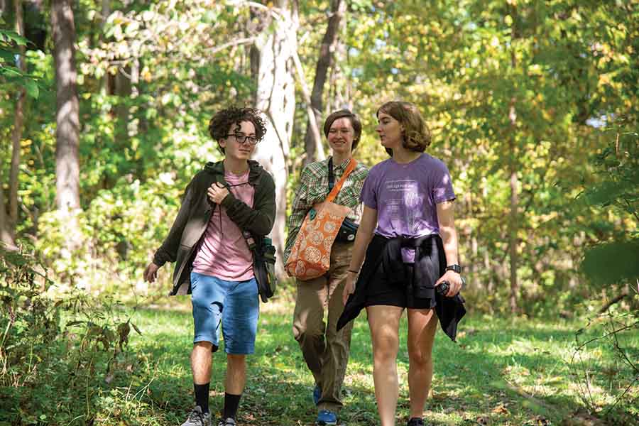 Three students walking in Green Oaks during an LLC