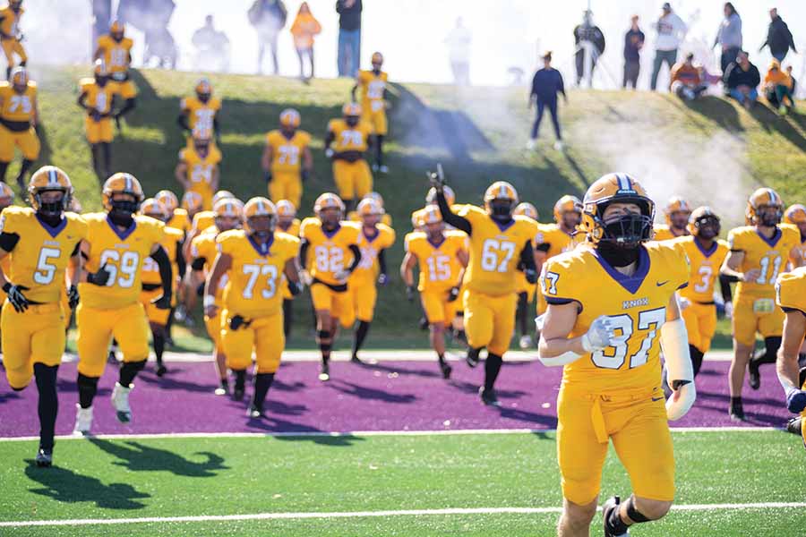 The football team running down the hill in the Knosher Bowl. 