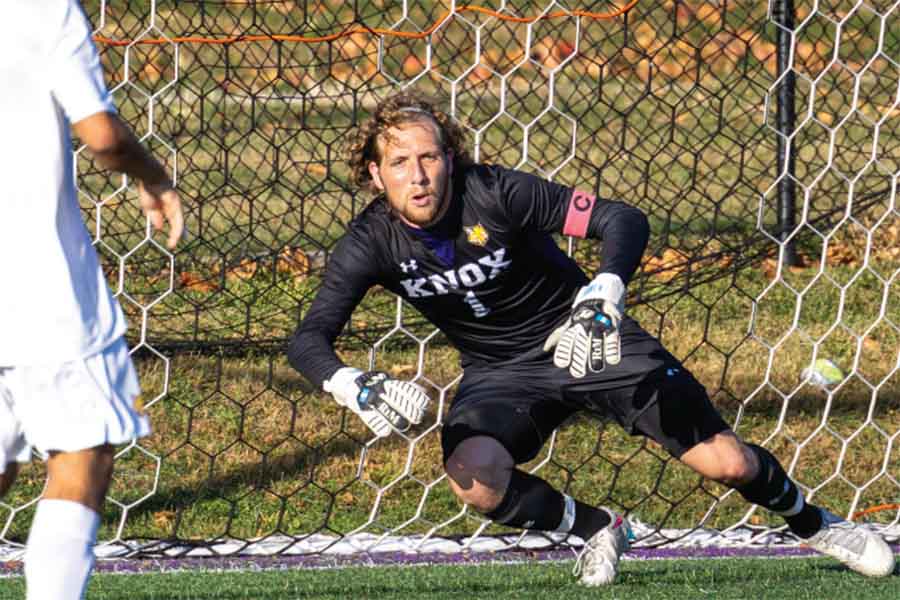 Prairie Fire goalkeeper Nicolas Lantzendorffer ’25 lunges to his right to attempt blocking a shot from hitting the back of the net.