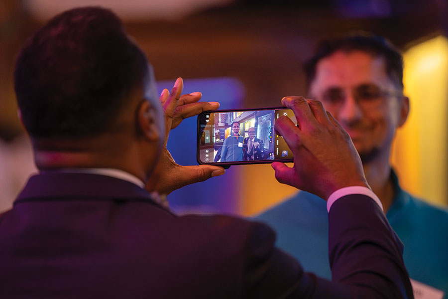 President C. Andrew McGadney takes a photo of Provost & Dean of the College Michael Schneider and Shahab Mushtaq ’97 at the St. Louis Venture Boldly event.