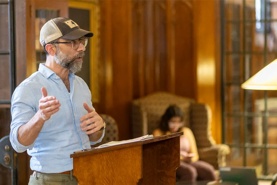 Professor Nicholas Regiacorte stands at a podium in the Seymour Library.