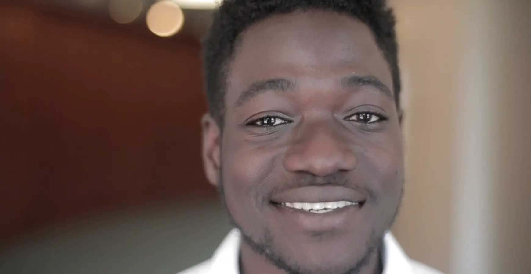 A students smiling at the camera.