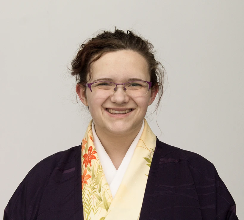 Bebheann standing in front of a white wall smiling at the camera.