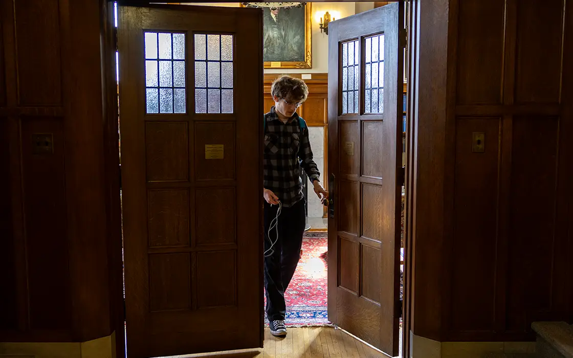 A Knox student opens a door in Seymour Library.