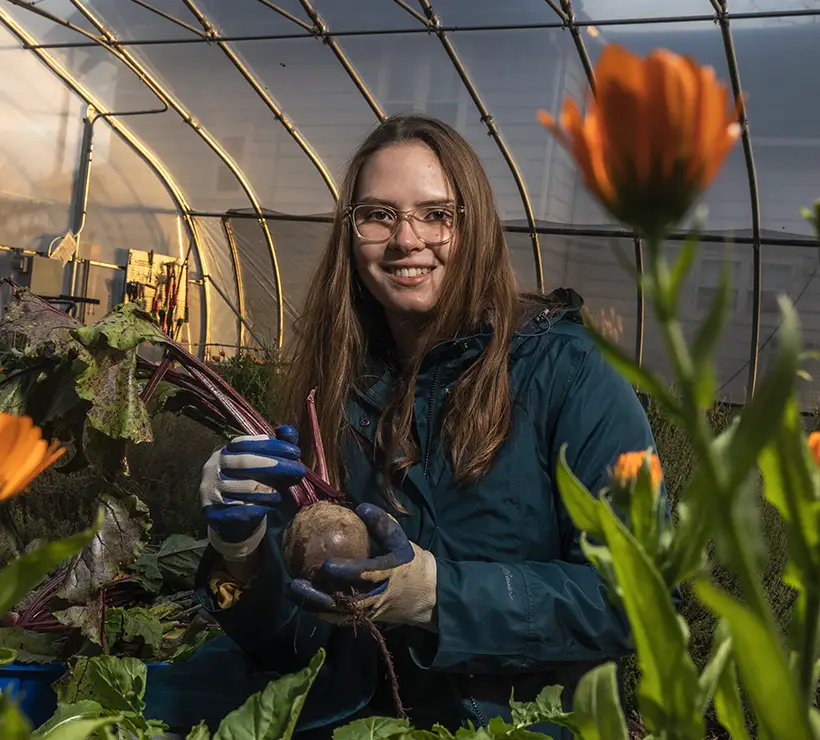 A photo of Teagan Springer with an orange flower.