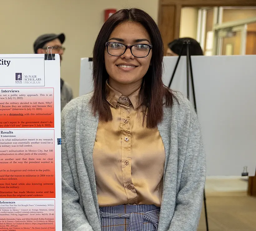 Julieanna Rueda standing in front of a presentation board.