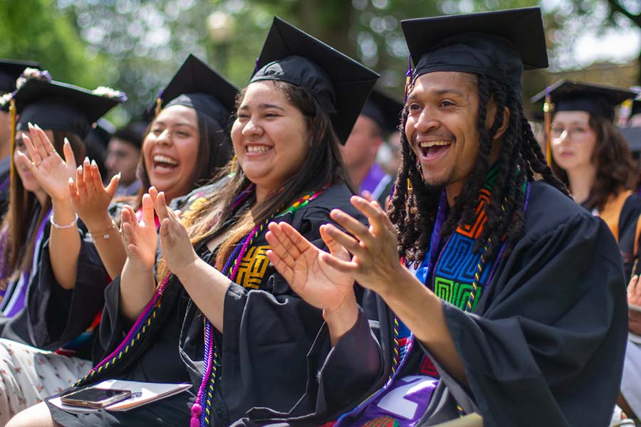 Graduates celebrating and clapping at the 2024 Knox College Commencement.