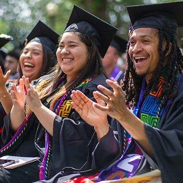 Graduates celebrating and clapping at the 2024 Knox College Commencement.